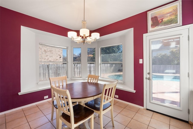 dining space featuring an inviting chandelier, baseboards, and light tile patterned flooring