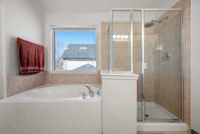 bathroom featuring a shower stall and a bath