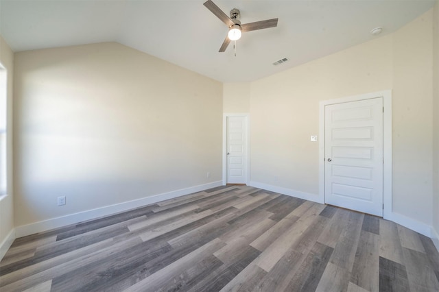 spare room with a ceiling fan, wood finished floors, visible vents, and baseboards