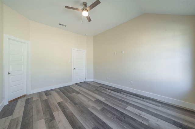 spare room with visible vents, ceiling fan, vaulted ceiling, wood finished floors, and baseboards