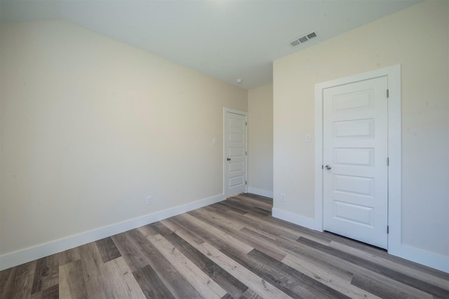 unfurnished bedroom with visible vents, baseboards, and wood finished floors