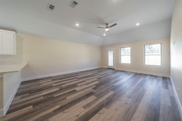 unfurnished living room featuring lofted ceiling, wood finished floors, visible vents, and baseboards