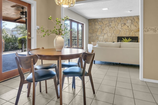 dining area with light tile patterned floors, a textured ceiling, a fireplace, and a wealth of natural light