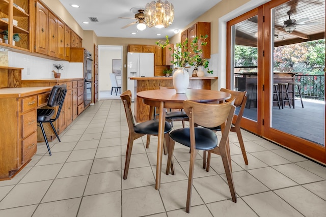 dining space with light tile patterned floors, ceiling fan with notable chandelier, visible vents, and recessed lighting