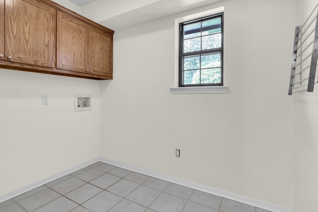 clothes washing area featuring hookup for a washing machine, cabinet space, baseboards, and light tile patterned floors