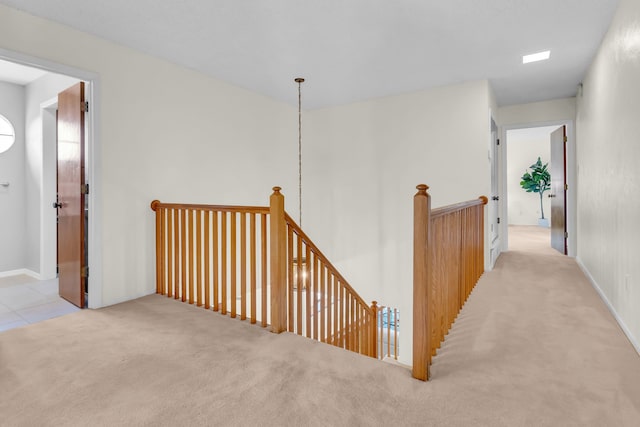 hall featuring carpet and an upstairs landing