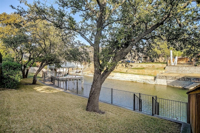 view of yard with a water view and fence