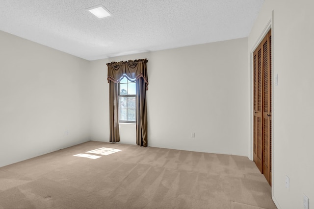 carpeted spare room featuring a textured ceiling