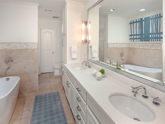 full bathroom with a freestanding tub, a sink, tile walls, and double vanity