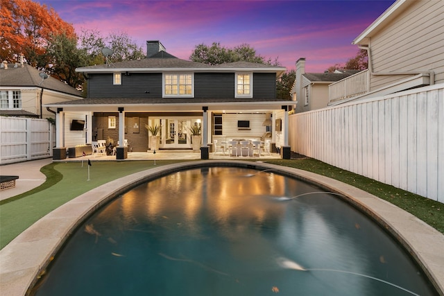 back of house featuring a patio, a chimney, a fenced backyard, and a fenced in pool