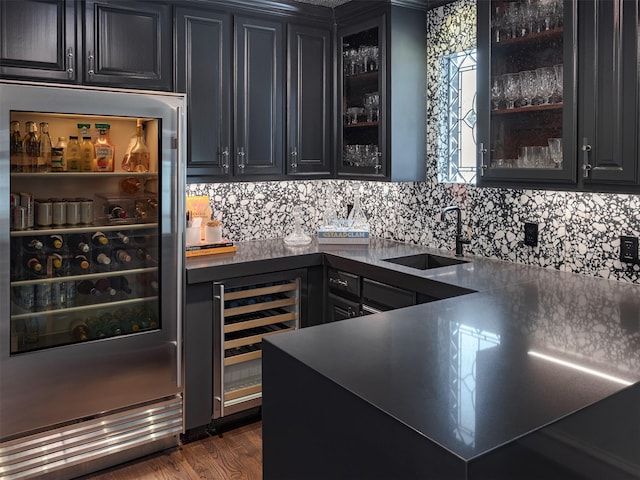 bar with beverage cooler, dark wood-style floors, a sink, and wet bar