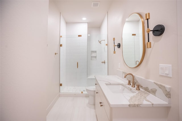 bathroom with toilet, visible vents, vanity, baseboards, and a stall shower