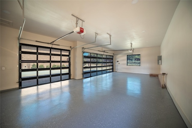 garage featuring a garage door opener, electric panel, and baseboards