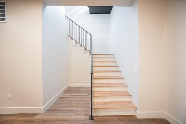 stairs with baseboards and wood finished floors