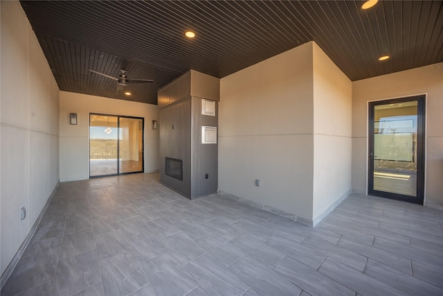 interior space featuring wooden ceiling, ceiling fan, a fireplace, and recessed lighting