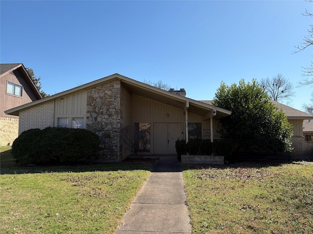 mid-century home with stone siding, brick siding, board and batten siding, and a front yard