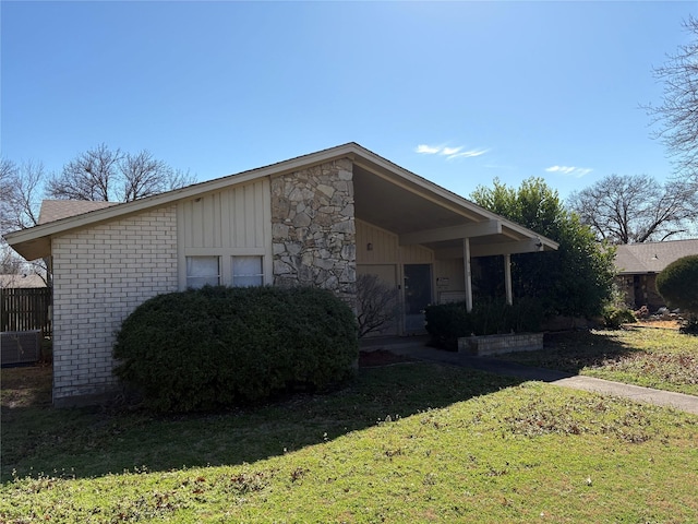 view of front facade with stone siding and a front yard