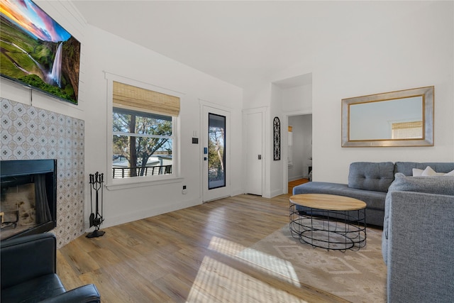 living room with baseboards, a tiled fireplace, and wood finished floors