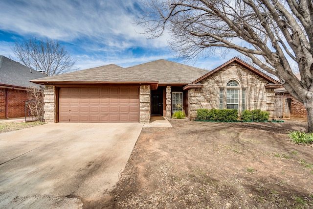 ranch-style house featuring concrete driveway, brick siding, an attached garage, and a shingled roof