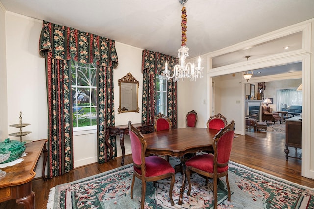 dining area featuring crown molding, a fireplace, and wood finished floors