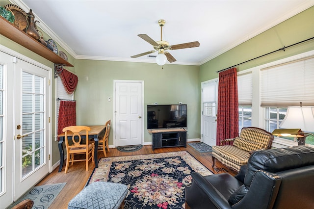 living area with plenty of natural light, ornamental molding, and wood finished floors