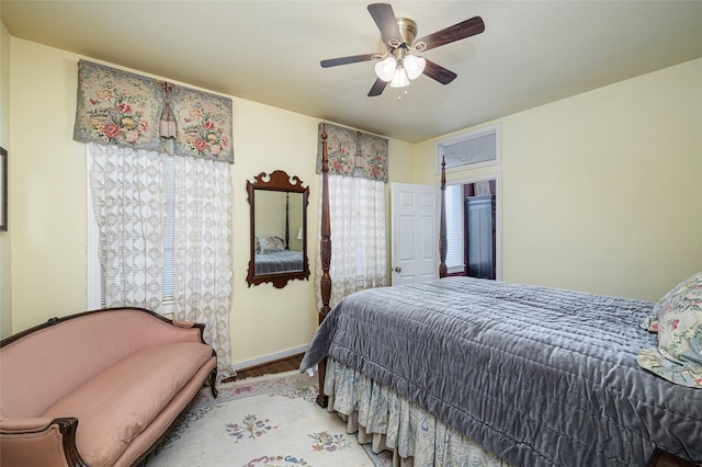 bedroom with a ceiling fan, baseboards, and wood finished floors