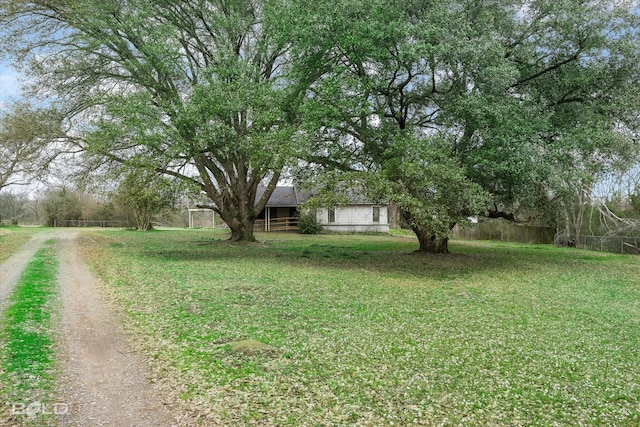 view of yard featuring driveway and fence