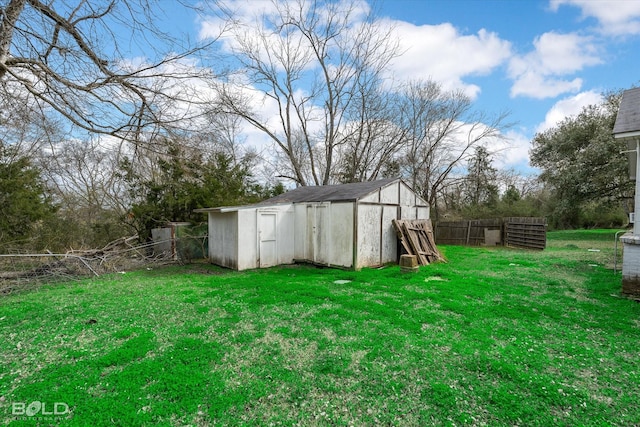 view of yard featuring a shed, fence, and an outdoor structure