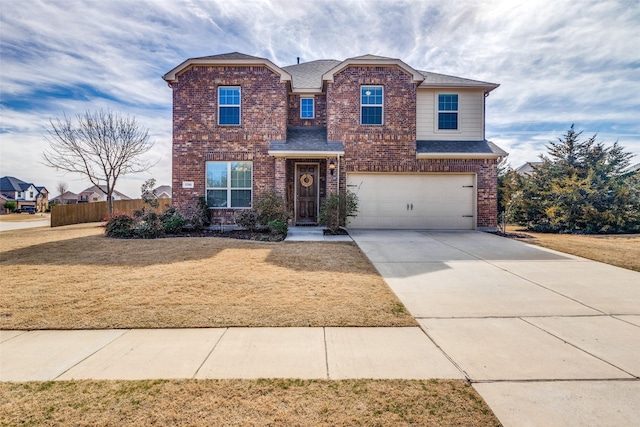 traditional-style home featuring brick siding, fence, a garage, driveway, and a front lawn