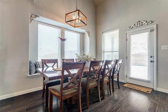 dining room with a notable chandelier, dark wood finished floors, and baseboards