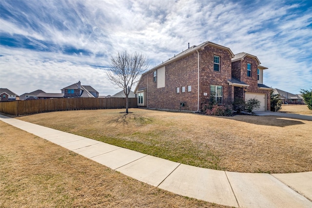 view of property exterior with a garage, brick siding, fence, and a lawn