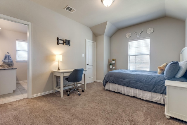 carpeted bedroom featuring lofted ceiling, visible vents, and baseboards