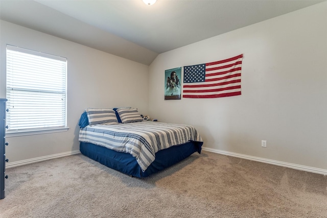 carpeted bedroom featuring lofted ceiling and baseboards