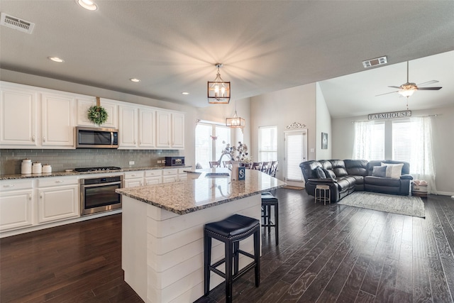 kitchen featuring stainless steel appliances, dark wood-style flooring, a sink, and visible vents