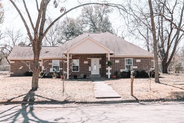 view of front of home with roof with shingles and brick siding