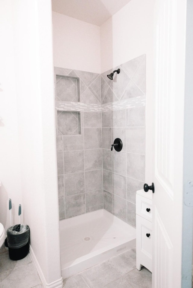 full bath with tile patterned flooring, a shower stall, toilet, and baseboards