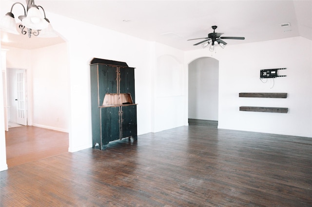 empty room with visible vents, arched walkways, wood finished floors, and ceiling fan with notable chandelier