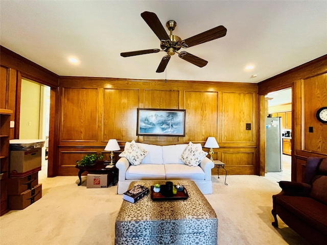 living room featuring light carpet, ceiling fan, and wood walls