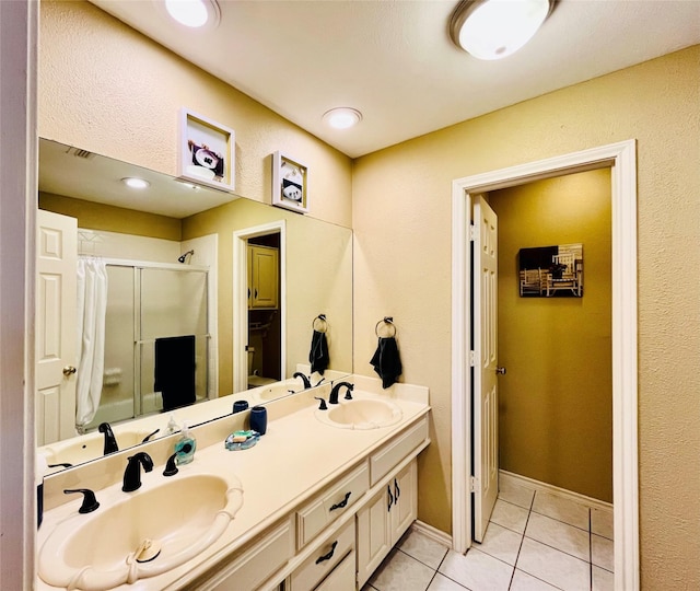 full bathroom with a sink, double vanity, tile patterned flooring, and a shower stall