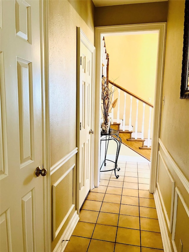 hallway with stairs and light tile patterned floors