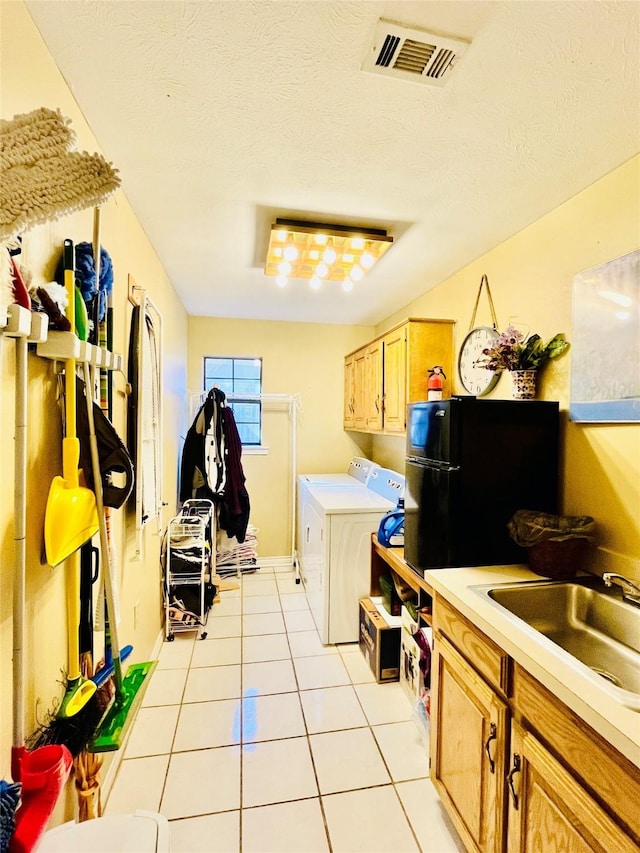 washroom with light tile patterned flooring, separate washer and dryer, a sink, visible vents, and cabinet space