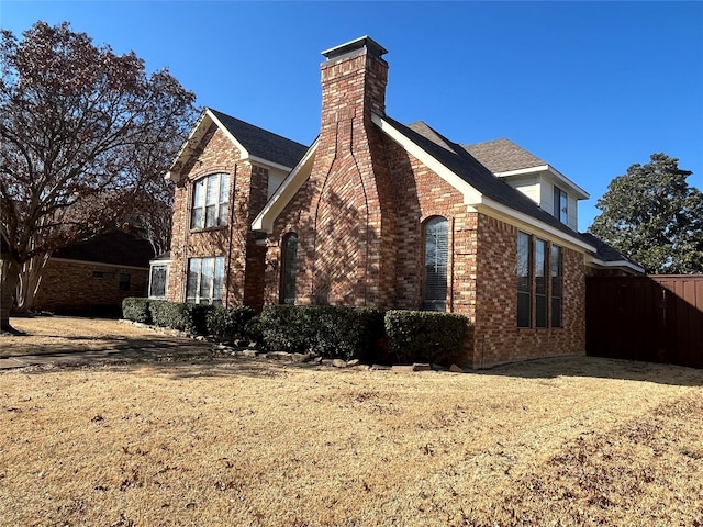 view of side of property with brick siding and a chimney