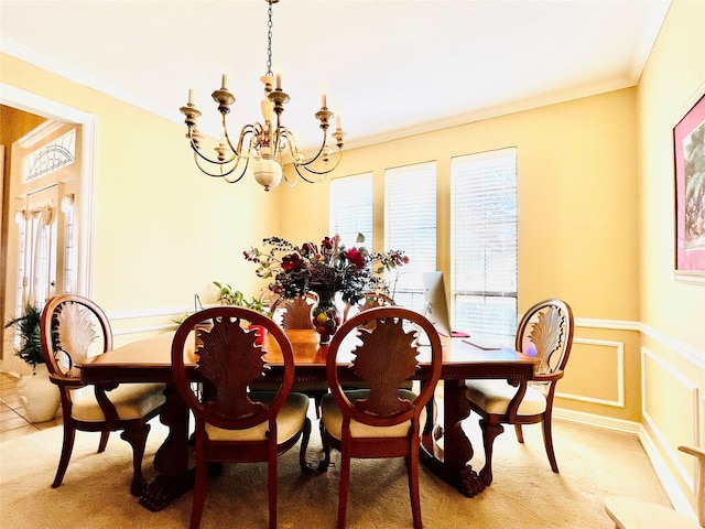 dining area with a chandelier, ornamental molding, and light colored carpet