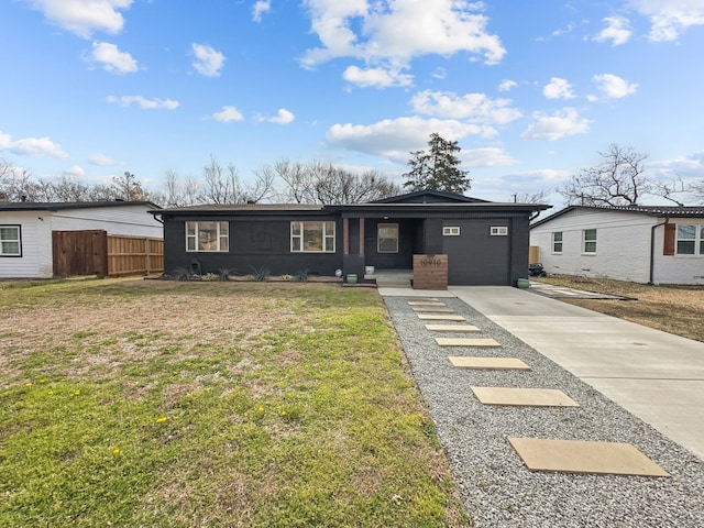 view of front of home with a garage, a front yard, concrete driveway, and fence