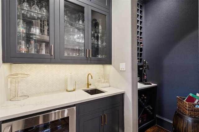 bar with a textured wall, wine cooler, backsplash, indoor wet bar, and a sink