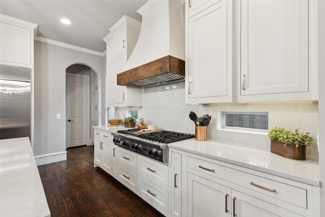 kitchen with crown molding, light countertops, custom range hood, appliances with stainless steel finishes, and white cabinetry