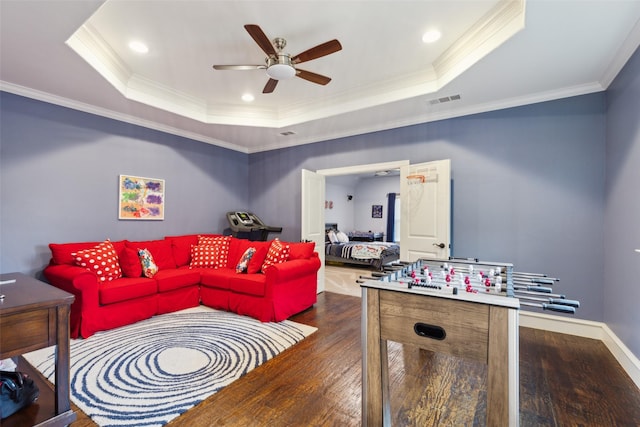 rec room featuring wood finished floors, visible vents, a ceiling fan, a raised ceiling, and crown molding