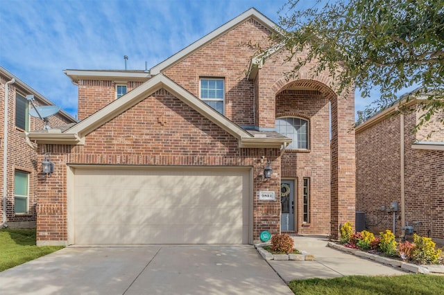 traditional home with driveway, brick siding, and an attached garage