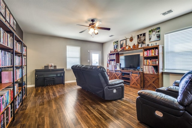 living room with a ceiling fan, wood finished floors, visible vents, and baseboards