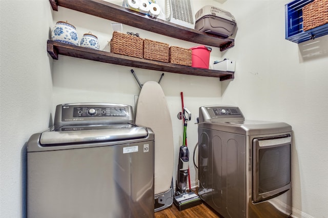 washroom with laundry area, washing machine and clothes dryer, and dark wood finished floors